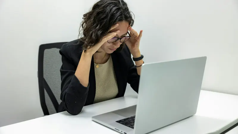 A person looking carefully at a laptop screen while researching online
